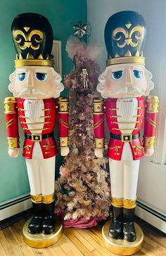 two nutcrackers standing next to a christmas tree