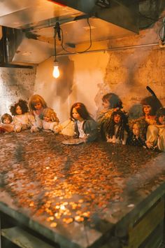 a group of dolls sitting on top of a counter in a room filled with coins