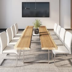 a long wooden table with white chairs and a potted plant in the center is shown