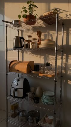 a kitchen shelf filled with pots and pans