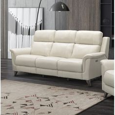 Sleek and modern, this power-reclining sofa lets you lean back and veg out after a long day. The farthest left and right seats feature headrests and backs that tilt back with the push of a button. Next to these buttons are USB ports to keep electronics charged. This sofa has a solid and engineered wood frame and rests on dark brown tapered dowel legs for a mid-century vibe. The rest of this piece is wrapped in a mix of leather and vinyl. And a foam-packed interior with pocket springs provide all Modern Reclining Sofa Living Room, Modern Reclining Sofa, Reclining Leather Sofa, Cream Sofa Living Room, Modern Recliner Sofa, Reclining Sofa Living Room, Cream Leather Sofa, Den Furniture, Leather Reclining Sectional