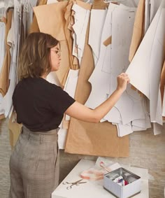 a woman is working on some paper clothes