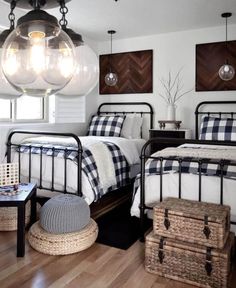 two beds in a bedroom with plaid sheets and blankets on them, one is black and the other is white