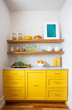 a kitchen with yellow cabinets and white walls