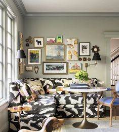 a living room filled with furniture and pictures on the wall