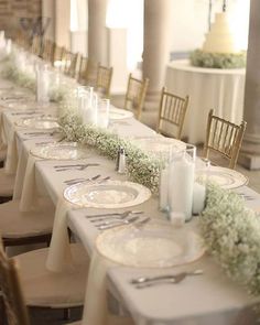 a long table with white plates and silverware on it is set for a formal dinner