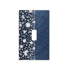 a light switch cover with blue jeans and white flowers on the front, and diamonds in the back