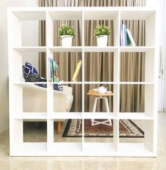 a living room with a white book shelf filled with books