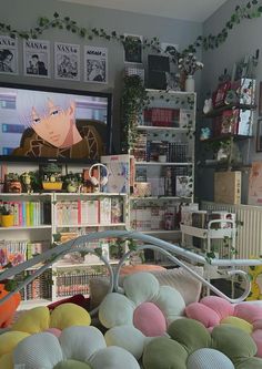 a room filled with lots of different colored balls in front of a flat screen tv