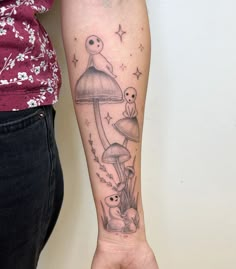 a person with a tattoo on their arm holding up a mushroom and some other things