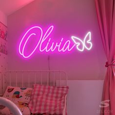 a pink neon sign above a bed in a child's room that reads, ollivia