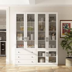 a large white cabinet with glass doors in a living room next to a potted plant