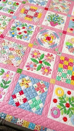 a pink quilt with many different designs on it