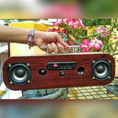 a person is holding an old radio in front of some flowers and other things that are on display