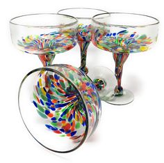 four colorful wine glasses sitting next to each other