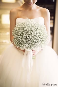 a bride holding a bouquet of baby's breath