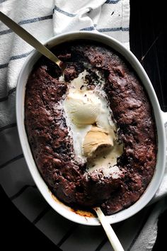 a bowl filled with pudding and ice cream on top of a striped table cloth next to a spoon