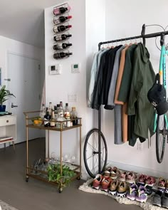 a bike is hanging on the wall next to a rack with shoes and other items