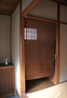 an empty room with a wooden cabinet and mirror on the wall in front of it