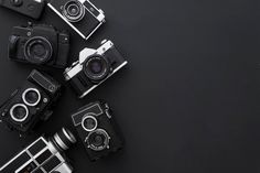 several different types of cameras sitting next to each other on a black surface with space for text