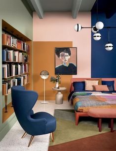 a bedroom with a bed, chair and bookshelf