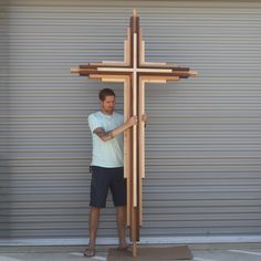 a man standing next to a wooden cross