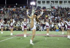 cheerleaders perform on the field during a football game