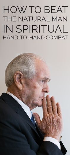 an older man in a suit and tie with his hands clasped to his chest, standing against a sign that says how to beat the natural man in spiritual hand - to - to - to - hand combat