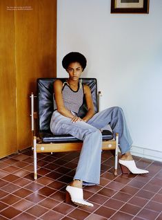 a woman sitting in a chair with her legs crossed