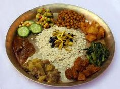 a metal plate topped with lots of different types of food on top of rice and beans