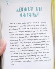 a person holding up a book in their hand with the title'align yourself body, mind and heart '