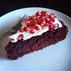 a piece of chocolate cake with pomegranates on top