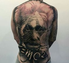 the back of a man's body with tattoos on his chest and shoulder, which has an image of a lion