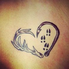 a tattoo on the back of a woman's shoulder with a dog paw and heart