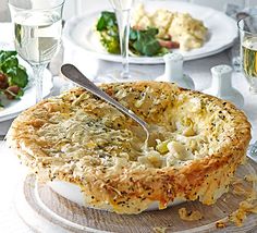 a pie is sitting on a table with wine glasses