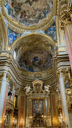 an ornately decorated church with gold and blue paint on the walls, ceiling and pews