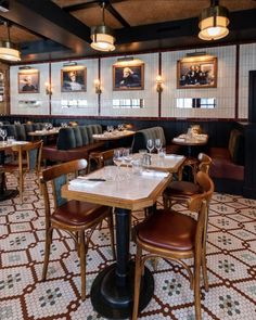 a restaurant with tables, chairs and pictures on the wall