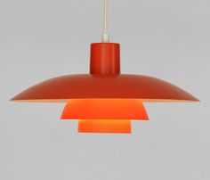 an orange light hanging from a ceiling fixture