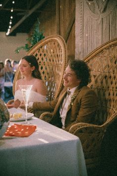 two people sitting at a table with drinks