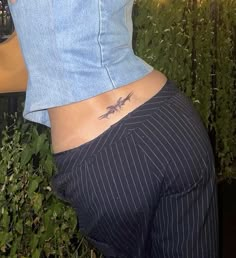 a woman's lower back with a scorpion tattoo on her left side ribcage