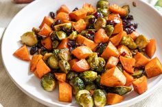 a white plate topped with brussel sprouts and sweet potatoes