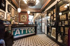 the inside of a tattoo shop with lots of framed pictures on the walls and ceiling