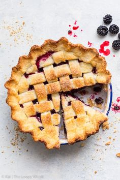 blackberry pie on a plate with berries around it and text overlay that reads blackberry pie