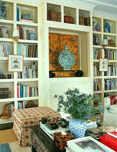 a living room filled with lots of bookshelves covered in pictures and vases