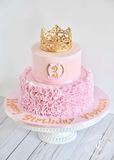 a pink and gold birthday cake with a crown on top