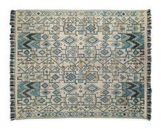 an old rug with blue and beige colors on the bottom, it has fringes