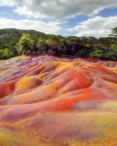 colorfully colored hills with trees in the background