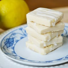 three pieces of cake sitting on top of a blue and white plate next to a lemon