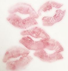 some pink lips are on a white surface