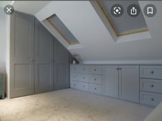 an attic bedroom with gray cabinets and carpeted flooring is featured in this image